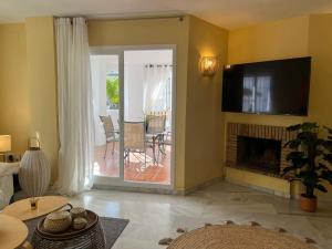 un salon avec une cheminée et une télévision dans l'établissement Beautiful 2 bedroom Apartment in Puerto Banus !, à Marbella