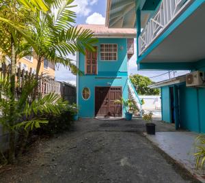 a blue house with a door and trees in front at Beach Studio in Crown Point in Bon Accord