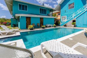 a swimming pool in front of a blue house at Beach Studio in Crown Point in Bon Accord