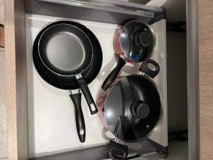 three pots and pans are hanging in a drawer at Estadía Allison in Guatemala