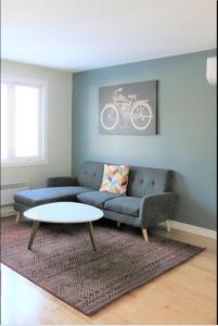 uma sala de estar com um sofá e uma mesa em Family-Friendly 3BR Home with Backyard em Montreal