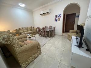 uma sala de estar com sofás, uma televisão e uma mesa em MAKKAH AL RUSAIFAH Apartment em Meca