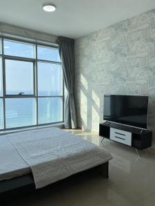 a bedroom with a bed and a flat screen tv at Sunset Beach View Holiday Homes in Ajman 