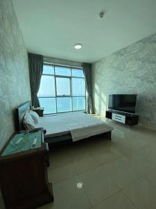 a bedroom with a bed and a flat screen tv at Sunset Beach View Holiday Homes in Ajman 