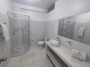 baño blanco con ducha y lavamanos en La Casa de Algodon, en Huacho