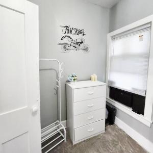 een witte kamer met een dressoir en een bord aan de muur bij Sport Private Entrance, Near CP & SF, W/D, Pet OK in Sandusky