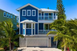 une maison bleue sur la plage avec des palmiers dans l'établissement Ocean Star! 7 Bdrms, 7 Baths! Beaches less than 5min walk to beach!, à Holmes Beach