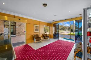 Habitación con alfombra roja en el suelo en Rowville International Hotel en Rowville