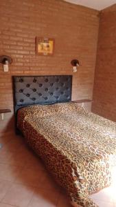 Dormitorio con cama con colcha de estampado de leopardo en Lo de Lili Departamentos Mina Clavero en Mina Clavero