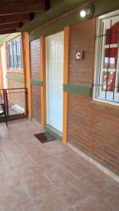 a room with a white door and a brick wall at Lo de Lili Departamentos Mina Clavero in Mina Clavero