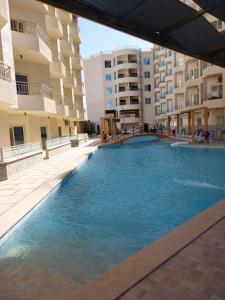 a swimming pool in front of some apartment buildings at La Quinta Heights in Hurghada