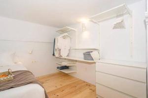 a white bedroom with a bed and a window at CASA ALTA LOFT in Málaga +5 photos