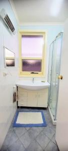 uma casa de banho com um lavatório e uma janela em Coastal Living in a Gorgeous House in Moonta Bay em Port Moonta