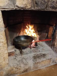 a pan over a fire in a brick oven at Bodega típica en El Molar sin camas ni dormitorios in El Molar