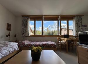 Schlafzimmer mit einem Bett und einem Fenster mit Bergblick in der Unterkunft The Window to the Mountains in Arosa