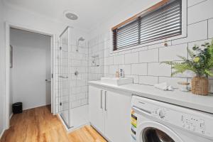 a white bathroom with a sink and a washing machine at Algona Views in Halls Gap +6 photos