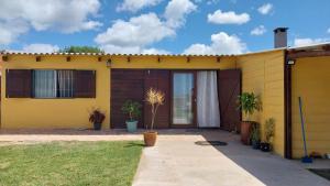 a yellow house with a front door and plants at Descanso al Paso Chuy in Chuy