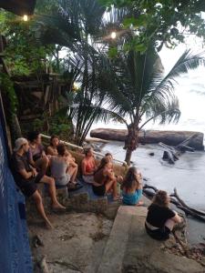 a group of people sitting on the steps near the beach at Casa Yemaya in Necoclí