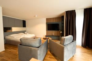 una camera d'albergo con due sedie e un letto di Cartea Apartments Zürich Airport a Opfikon