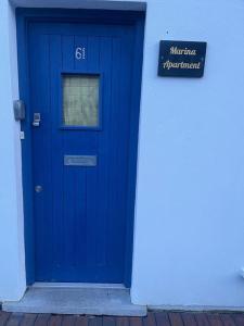 une porte bleue sur le côté du bâtiment dans l'établissement Marina Apartment Kinsale, à Cork