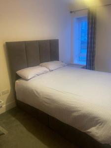 a large bed in a room with a window at Marina Apartment Kinsale in Cork