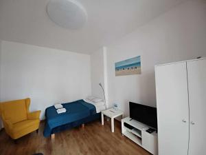 - une chambre avec un lit, une chaise et une télévision dans l'établissement Apartament Mona Lisa Sopot, à Sopot