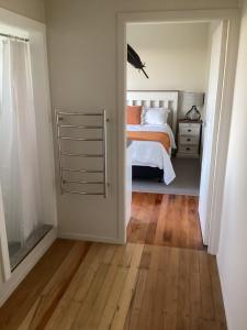1 dormitorio con 1 cama y suelo de madera en Robyn's Nest en Sentry Hill