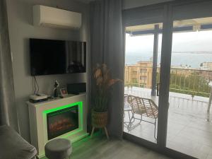 a living room with a green fireplace and a balcony at Appartement chez François in Salou