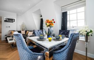 uma sala de estar com uma mesa e cadeiras azuis em Marble Arch Penthouse 1 Bed em Londres