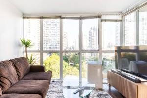 uma sala de estar com um sofá e uma mesa de vidro em Luxury 2-bedroom condo beach side Yaletown em Vancouver