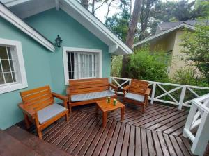 a deck with two benches and a table on a house at Casa equipada para 8 personas a tres cuadras del mar - Colibrí 1 in Mar Azul