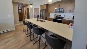 a kitchen with a large island with bar stools at Powder Heights #22 townhouse in Sun Peaks