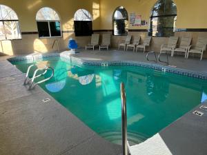 una gran piscina con sillas en un edificio en Days Inn by Wyndham Rio Rancho, en Rio Rancho