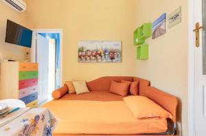 a living room with an orange couch in a room at LA CALETTA HOME in Villanova di Ostuni