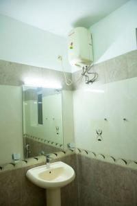 Golden Residencies - Colombo - 3 Bed Apartment في كولومبو: حمام مع حوض ومرآة كبيرة