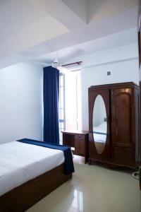 Golden Residencies - Colombo - 3 Bed Apartment في كولومبو: غرفة نوم بسرير ومرآة ونافذة