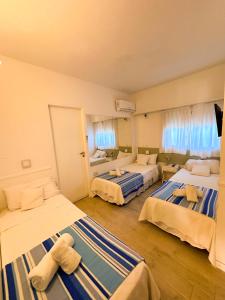 una habitación de hotel con 3 camas con ositos de peluche. en Tamanacos Hotel & Spa en Villa Gesell