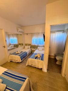 Habitación de hotel con 2 camas y aseo en Tamanacos Hotel & Spa en Villa Gesell