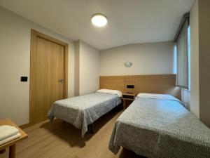 Habitación hospitalaria con 2 camas y ventana en Hotel Europa, en Arteixo