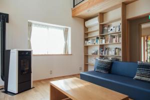 uma sala de estar com um sofá azul e uma mesa em PICA Yamanakako Village em Yamanakako