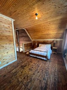 1 dormitorio con 1 cama en el techo de madera en Chalet Le Verdier, en Champlain