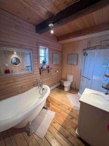 y baño con bañera, lavabo y aseo. en Chalet Le Verdier, en Champlain
