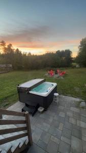 una bañera de hidromasaje en un patio en un campo en Chalet Le Verdier, en Champlain