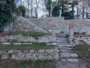 Eine alte Steinstützmauer mit Treppe in einem Hof in der Unterkunft Ty Domovoï, vue mer in Douarnenez