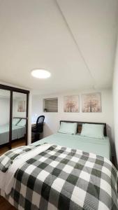um quarto com uma cama com um cobertor xadrez em 2 Bedroom Basement Suite in the heart of Laval em Laval