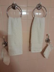 three white towels hanging on a wall in a bathroom at Kanalu Studio in Bouillante +92 photos