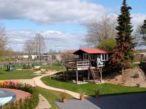 een speeltuin met een klein huis in een park bij Holiday home with motorboat in Olburgen