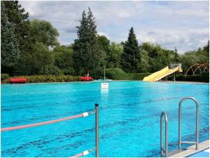 uma piscina com água azul e um escorrega em Apartment in Tauberbischofsheim em Tauberbischofsheim