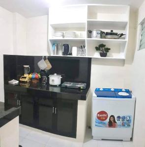 a kitchen with a black counter and a refrigerator at Kiwi Transient House in Tacondo