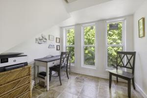 Holley House home في كابتيفا: مطبخ مع طاولة وكراسي ونوافذ